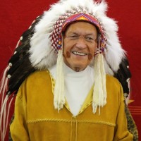 Father Jim Holland honoured with a headdress ceremony