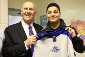 FC Edmonton Club Manager Rod Proudfoot presents a team jersey to Aboriginal soccer talent Kobe Blyan. 