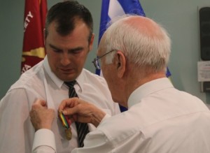 AVSA president Jack MacDonald pins a medal on veteran Shane Marchant