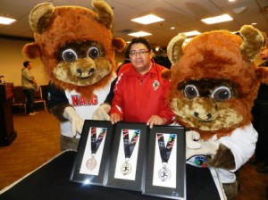 Saskatchewan CDC Association Chairman Stan Bobb, joins the NAIG Mascots in unvieling the beautiful 2014 NAIG medals. 