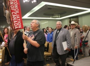  Alberta Elder Jerry Saddleback carries the TRC banner in Grand Entry on June 2, 2015, the day the Commissioners released the TRC Final Report summary in Ottawa. He is followed by the commissioners: Murray Sinclair, Wilton Littlechild and Marie Wilson.  Article by John Copley;   Photos by Terry Lusty 