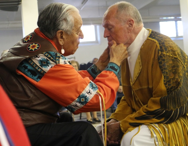 kanai Elder Martin EagleChild prepares Father Jim Holland for the headdress ceremony.