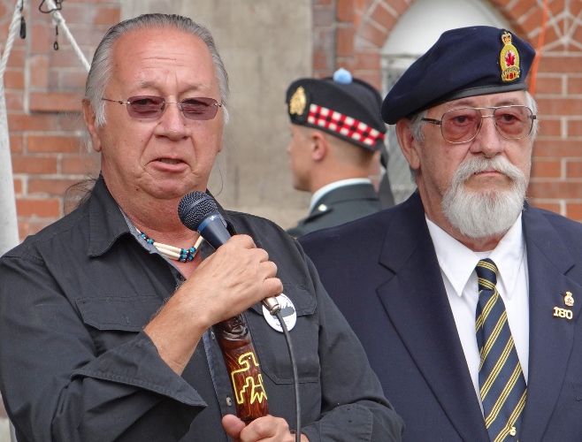 L. Richard Byce and R. Frank Byce, sons of war hero Charles Henry Byce.  Background: Member of Lake Superior Scottish Regiment Honour Guard. Photos supplied by Sculpture by Tyler Fauvelle