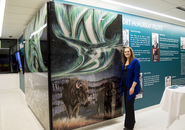 Amy Keller-Rempp poses with her installation at the Fort McMurray Airport. 